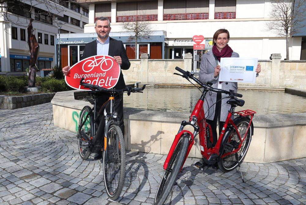 Verkehrslandesrat Heinrich Dorner und eine weitere Person präsentieren hinter Fahrrädern stehend das Ergebnis der Aktion Burgenland radelt 2021.